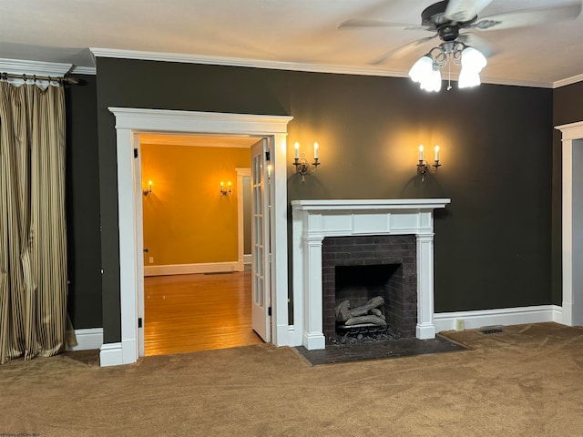 unfurnished living room featuring ceiling fan, ornamental molding, a brick fireplace, and hardwood / wood-style floors