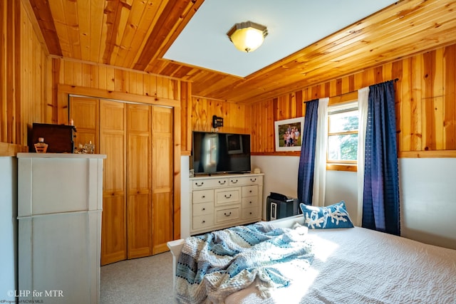 carpeted bedroom with wooden walls, a closet, and wooden ceiling