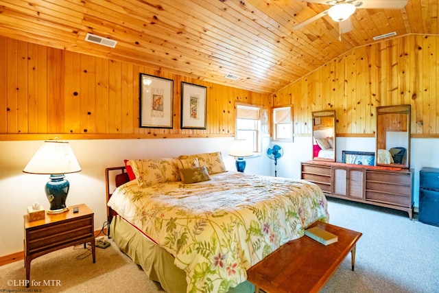 carpeted bedroom with ceiling fan, lofted ceiling, wood walls, and wooden ceiling