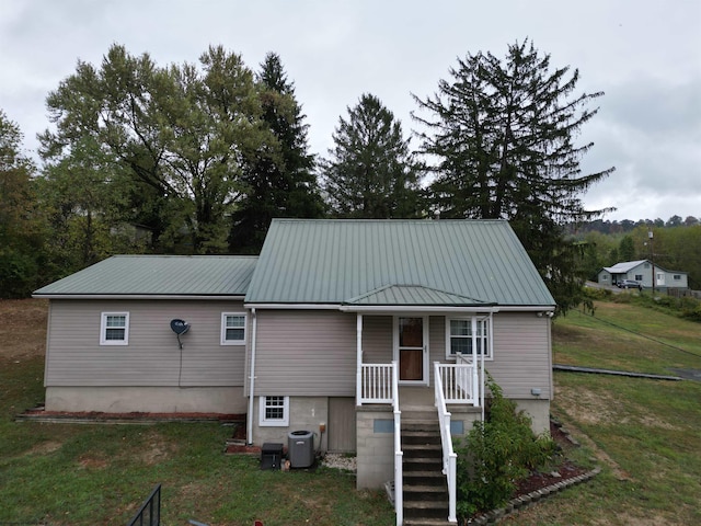 view of front of house with a porch, cooling unit, and a front yard