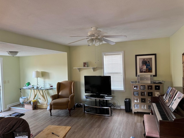 living room with hardwood / wood-style floors, a textured ceiling, and ceiling fan