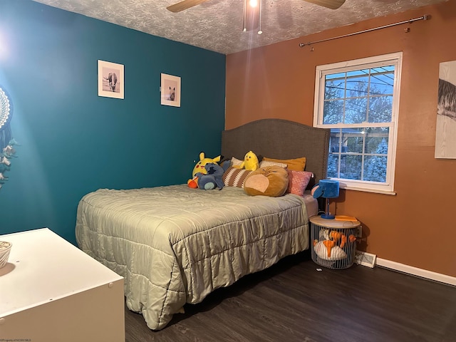 bedroom with ceiling fan, hardwood / wood-style flooring, and a textured ceiling