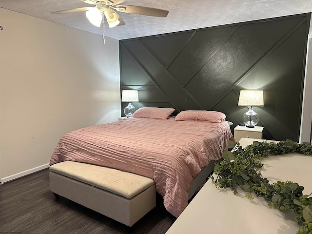 bedroom with dark wood-type flooring, a textured ceiling, and ceiling fan