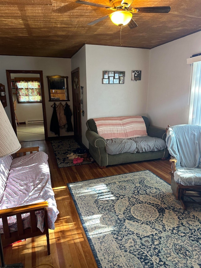 living room featuring ceiling fan, baseboard heating, and dark hardwood / wood-style flooring