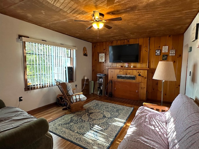 living room with wood ceiling, wood walls, hardwood / wood-style floors, and ceiling fan