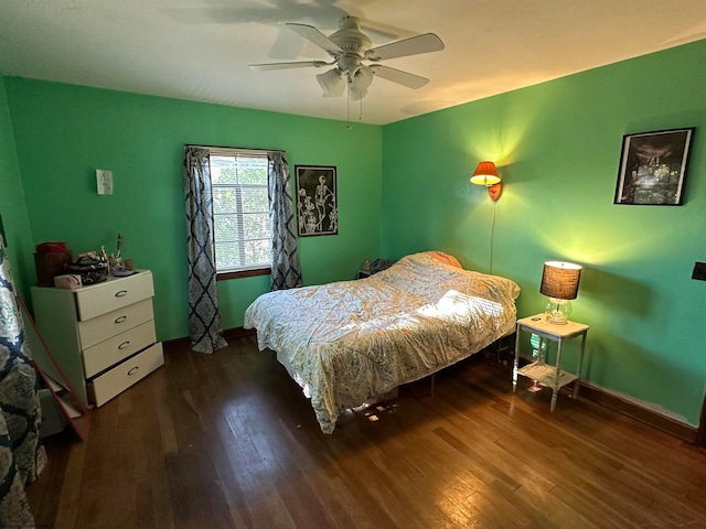 bedroom with dark hardwood / wood-style flooring and ceiling fan