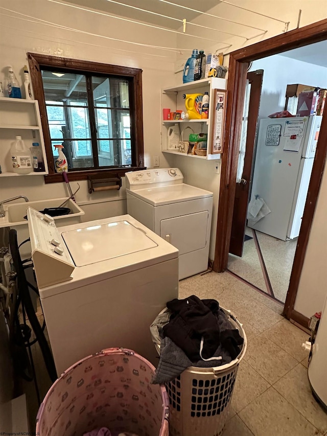 clothes washing area with light tile patterned flooring and washer and dryer