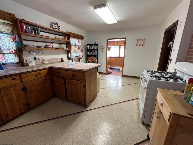 kitchen with white range with gas stovetop and kitchen peninsula