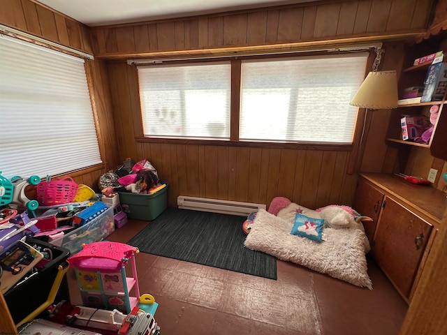 game room with a baseboard radiator, a healthy amount of sunlight, and wood walls