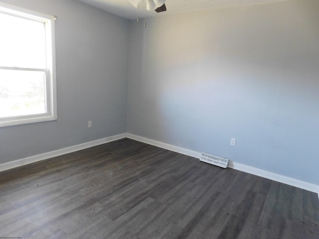 unfurnished room with dark wood-type flooring and ceiling fan