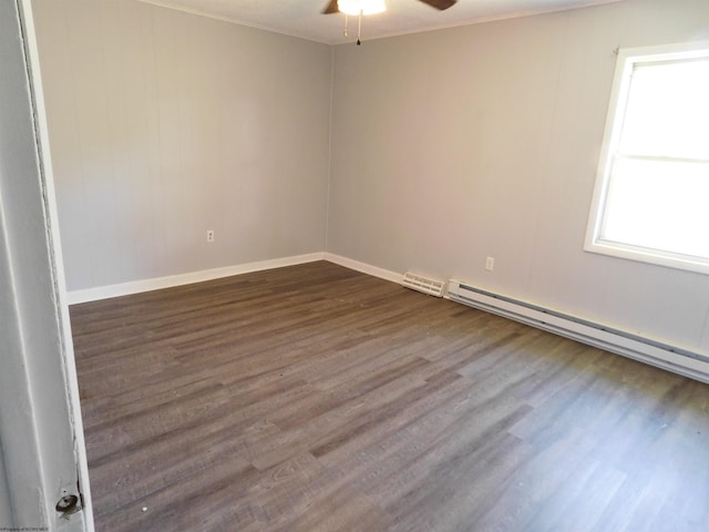 unfurnished room featuring ceiling fan, crown molding, a baseboard heating unit, and dark hardwood / wood-style floors