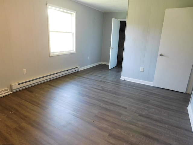 spare room with a baseboard radiator and dark hardwood / wood-style flooring