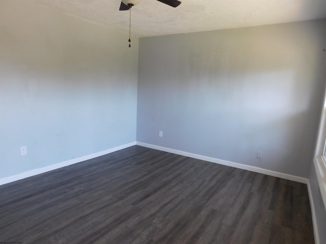 empty room with a textured ceiling, dark hardwood / wood-style floors, and ceiling fan