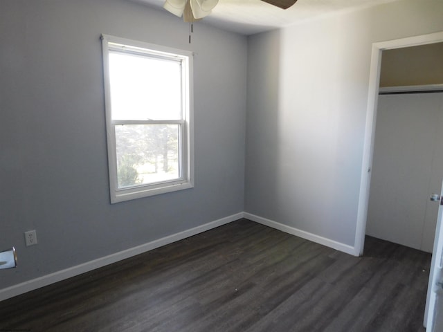 unfurnished bedroom with dark wood-type flooring, a closet, and ceiling fan