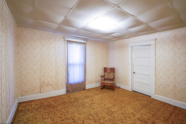 unfurnished room featuring a paneled ceiling and carpet