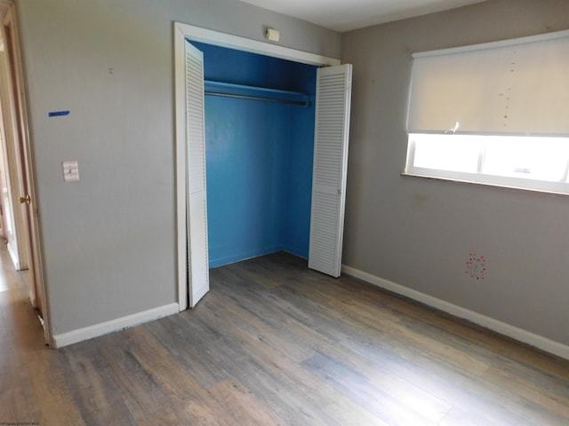 unfurnished bedroom featuring wood-type flooring and a closet