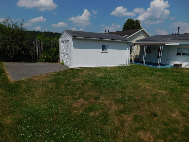 rear view of property featuring a patio, central AC, and a lawn