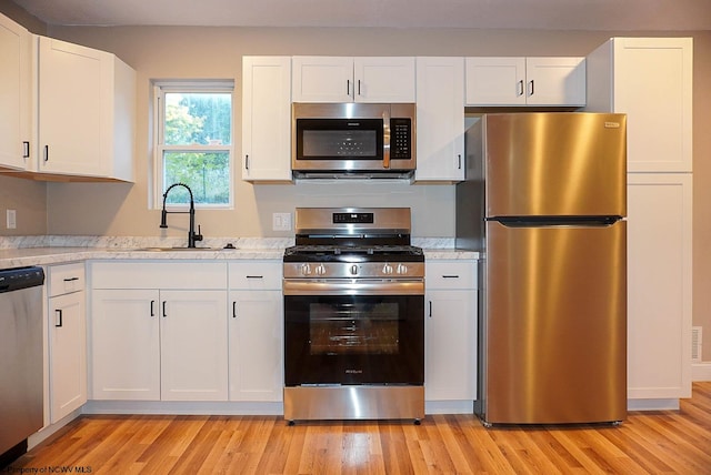 kitchen with appliances with stainless steel finishes and white cabinets