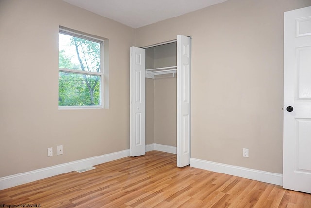 unfurnished bedroom featuring a closet and light hardwood / wood-style floors