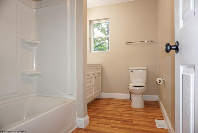 full bathroom featuring vanity, toilet, hardwood / wood-style flooring, and  shower combination