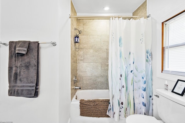 bathroom featuring shower / bath combination with curtain, toilet, and plenty of natural light