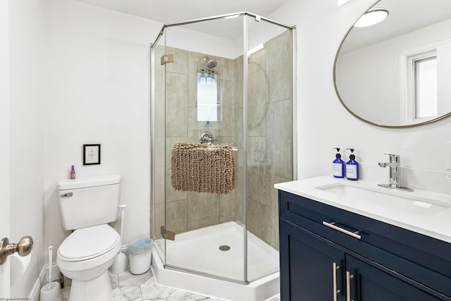 bathroom featuring a shower with door, vanity, and toilet