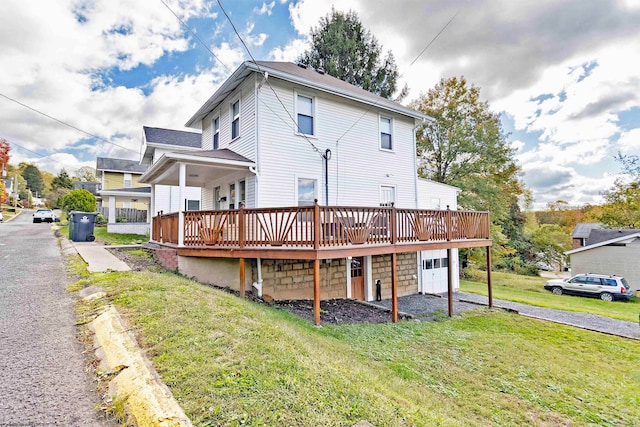 back of house featuring a deck and a lawn