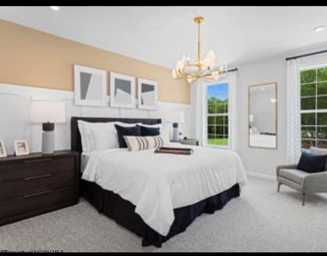 bedroom featuring an inviting chandelier and light colored carpet