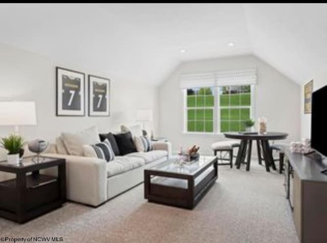 carpeted living room featuring vaulted ceiling