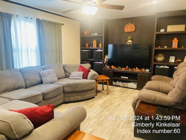 living room with ceiling fan, built in features, and light wood-type flooring