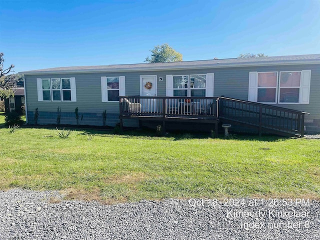 view of front of property with a wooden deck and a front lawn