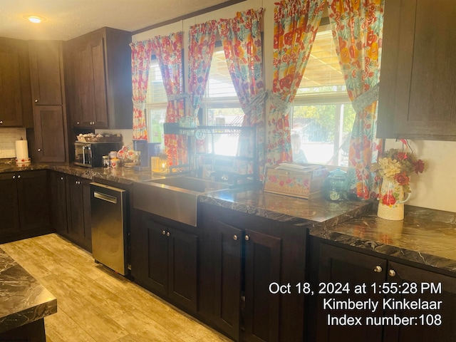 kitchen with dark brown cabinets, light wood-type flooring, and stainless steel dishwasher