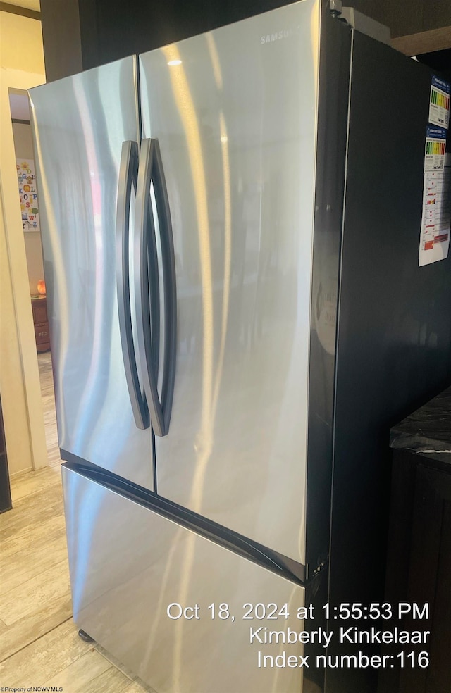 room details with light wood-type flooring and stainless steel refrigerator