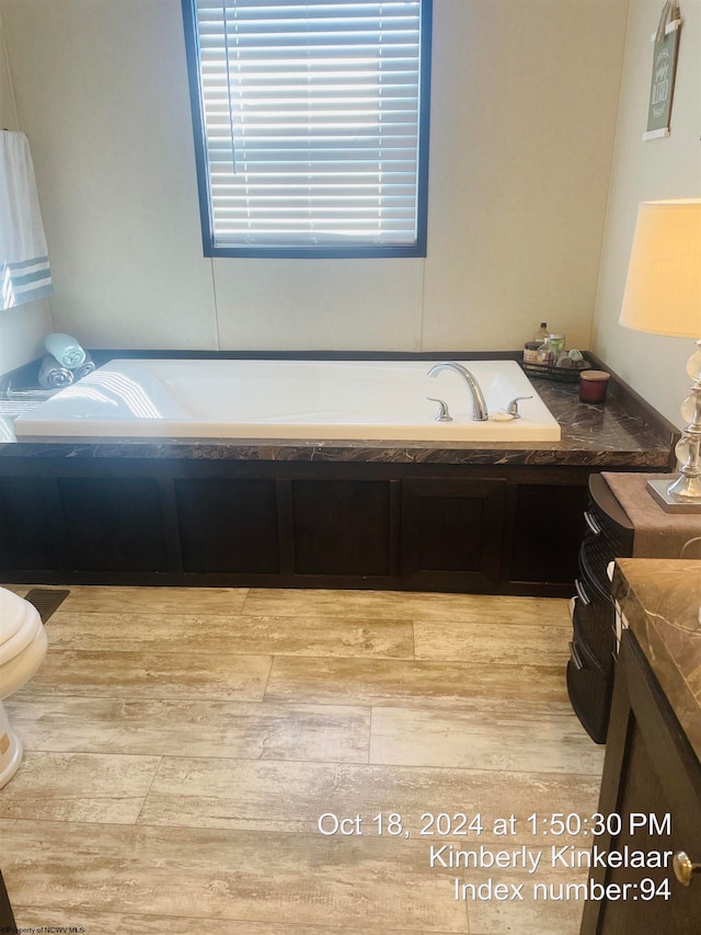 bathroom featuring vanity and tiled tub