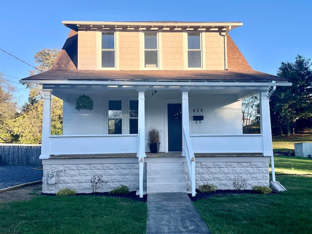 view of front of home with covered porch and a front lawn