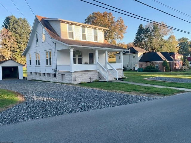 view of front of property featuring an outbuilding, a porch, and a front lawn