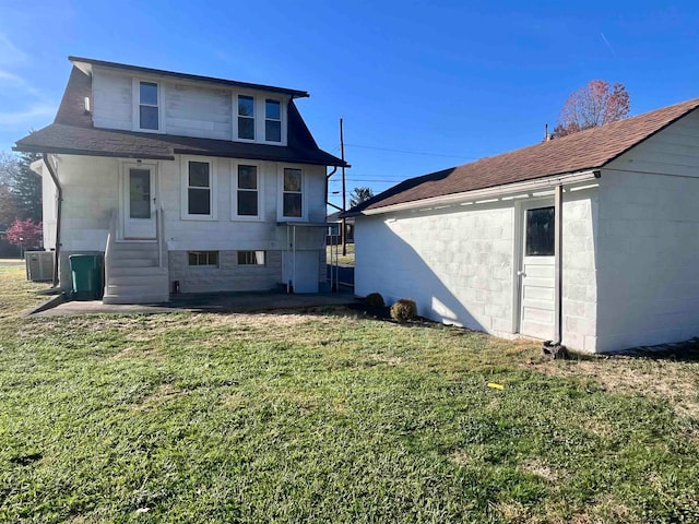 rear view of house featuring a lawn and central AC