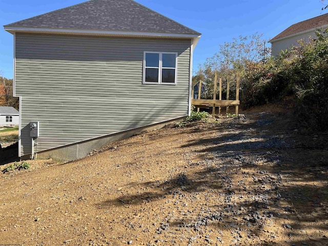 view of side of property featuring a shingled roof