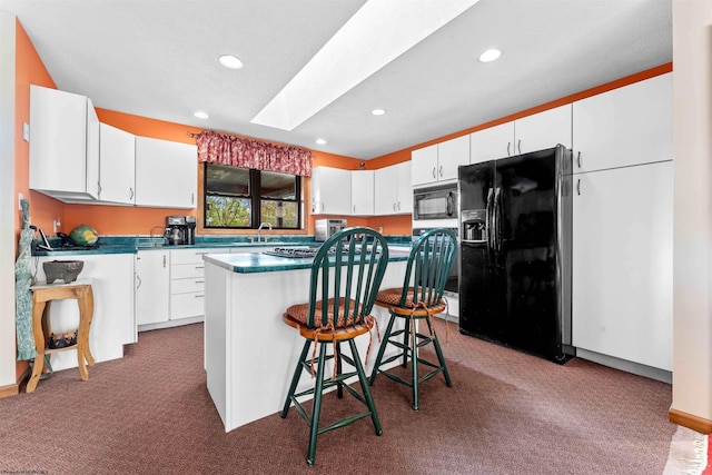 kitchen with black appliances, a kitchen bar, a kitchen island, carpet floors, and white cabinetry