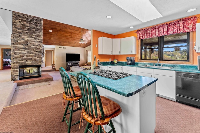 kitchen featuring light carpet, a breakfast bar, white cabinets, and black dishwasher