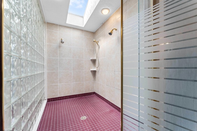 bathroom with a tile shower, tile walls, and tile patterned flooring