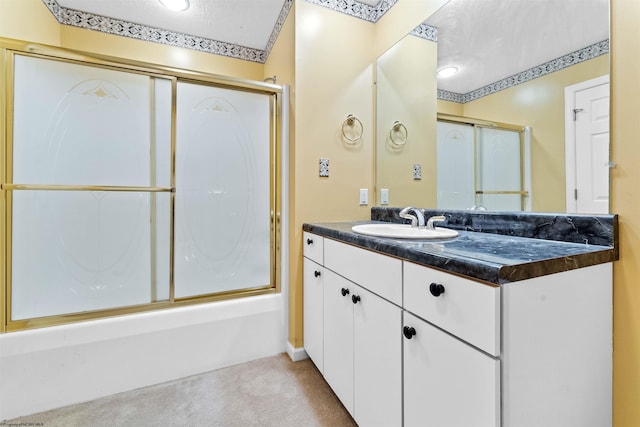 bathroom with vanity, enclosed tub / shower combo, and a textured ceiling