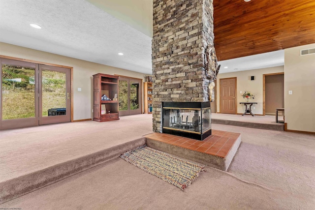 carpeted living room with a fireplace and a textured ceiling