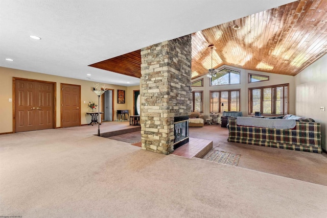 bedroom featuring ornate columns, wood ceiling, a stone fireplace, and carpet floors