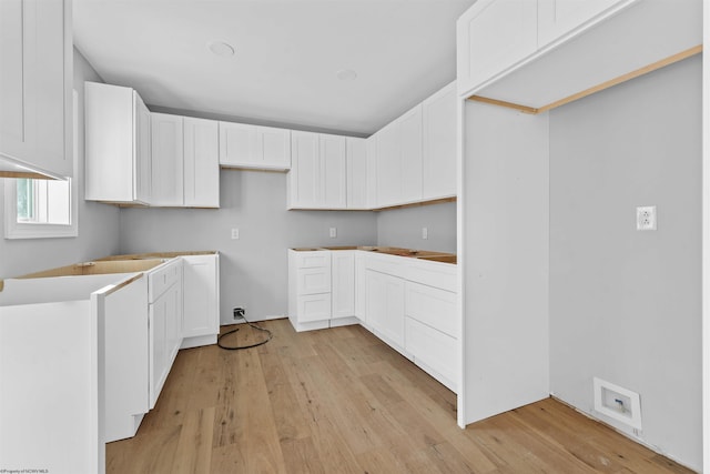 kitchen featuring light wood-type flooring and white cabinets