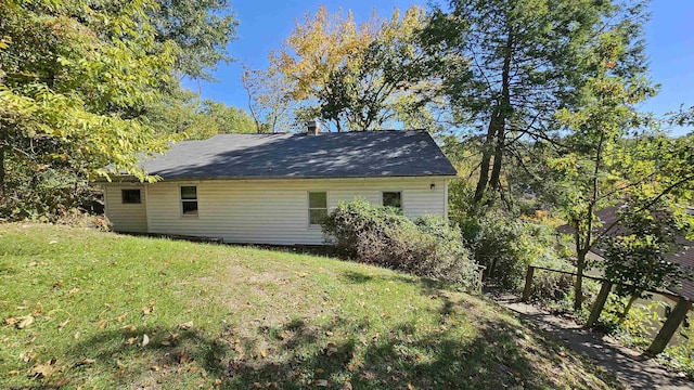 view of side of property featuring a chimney and a yard