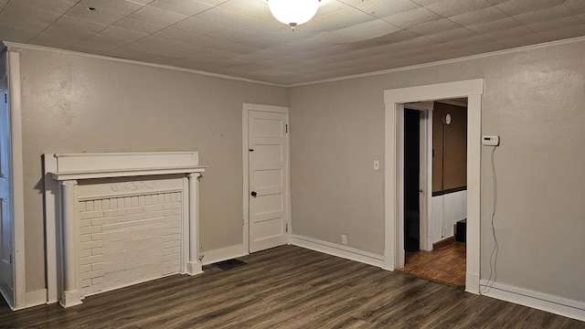 unfurnished living room with crown molding, dark wood-style floors, and baseboards
