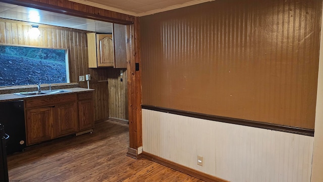 kitchen with crown molding, hardwood / wood-style floors, sink, and wooden walls