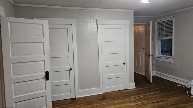 unfurnished bedroom featuring dark wood finished floors, baseboards, and ornamental molding