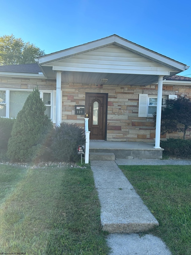 property entrance featuring covered porch and a yard